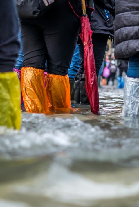 Flood on the streets, people wearing plastic bags on their shoes to walk through the water