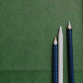 three pens on a green paper background