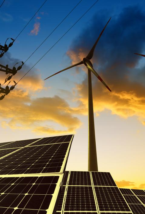 Erneuerbare Energien: Solarpaneele und Windräder vor Stromleitungen