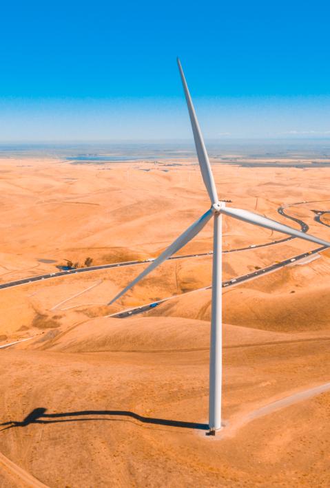 Ein Windkraftwerk in der Wüste von oben.
