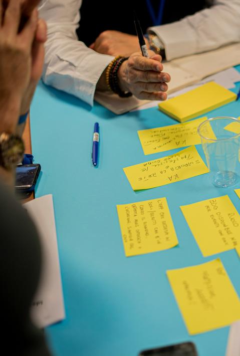 Gelbe Post-It-Zettel, die in einem Workshop beschrieben und verteilt werden