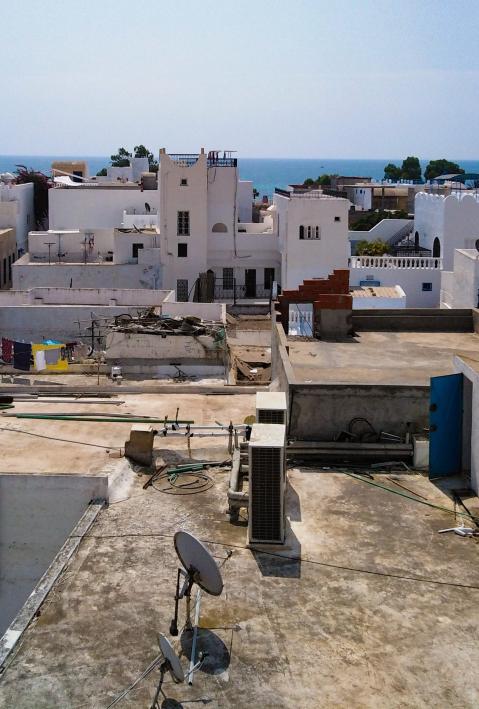 Tunesische Stadt mit weißen Häusern, das Meer im Hintergrund. 