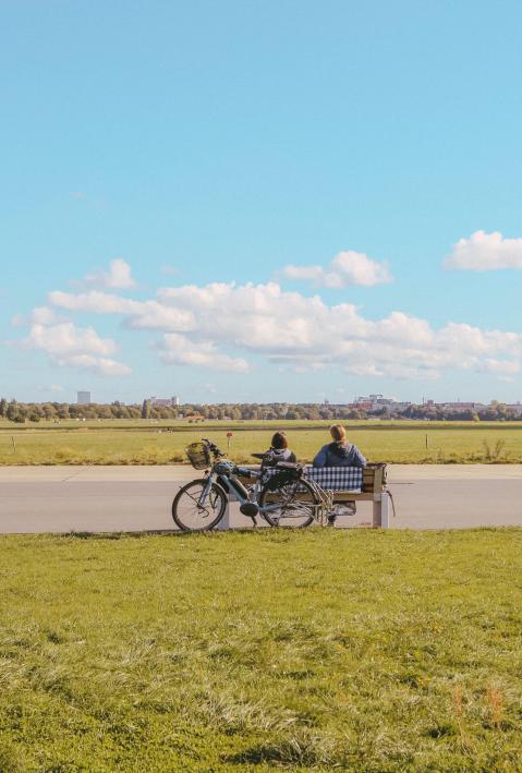 people sitting on a bench with view on former Tempelhof airport