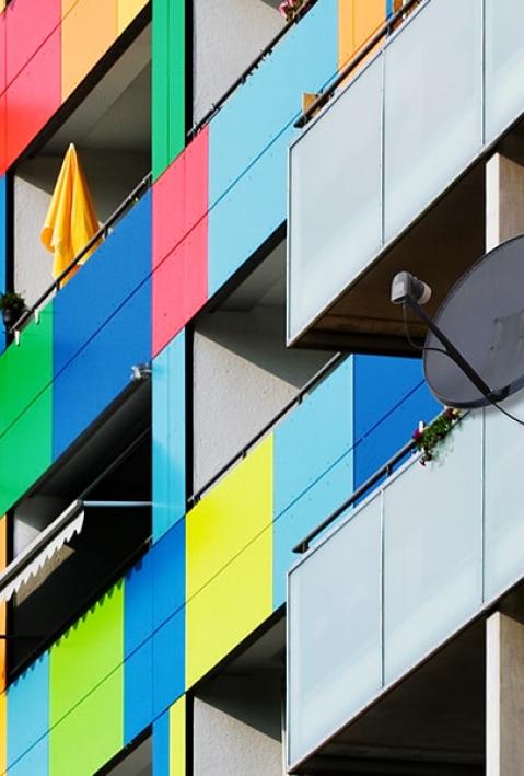 Ein Gebäude mit Balkonen, deren Fronten in farbige Vierecke angemalt sind