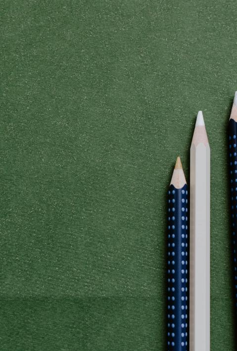 three pens on a green paper background