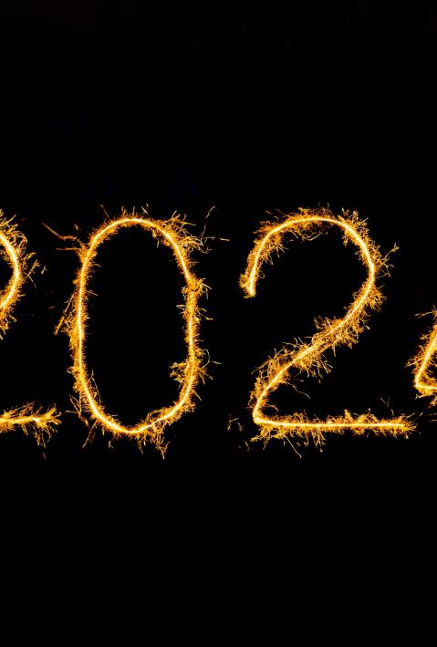 Ein dunkler Hintergrund mit dem Jahr 2024 als Wunderkerzenlicht geschrieben