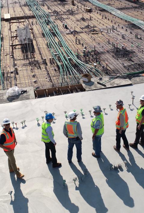 Construction workers standing on building site.