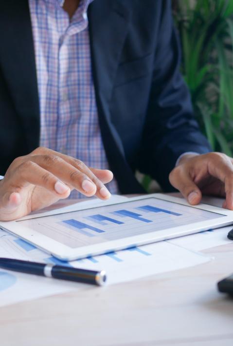 A man in a suit looks at statistics at his desk. 