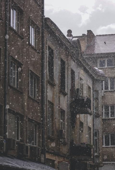Brown concrete buildings in snowfall