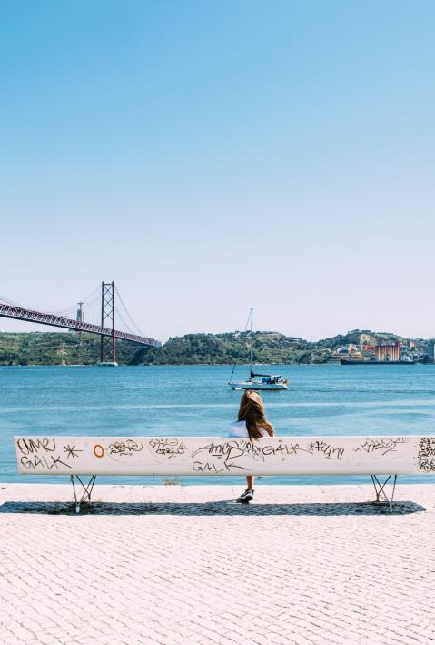 person sitting on a bench in Lisbon at the sea 