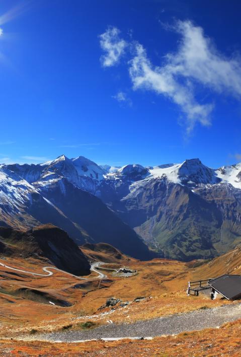 The picture was taken Fisheye lens. Austrian Alps. Excursion to the picturesque panoramic way Grossgloknershtrasse. Sunny day in early autumn. Great highway winds between hillsides yellowed