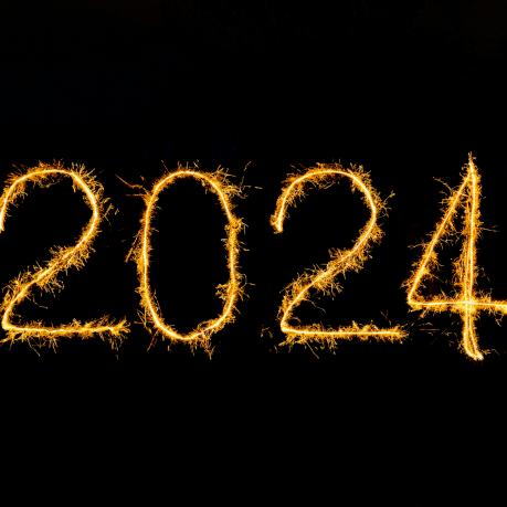 Ein dunkler Hintergrund mit dem Jahr 2024 als Wunderkerzenlicht geschrieben