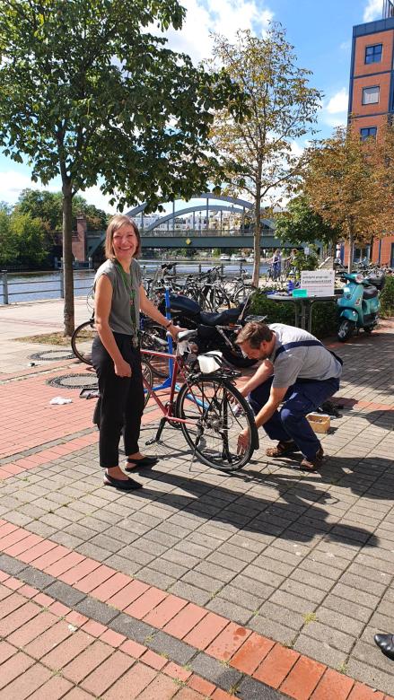 adelphi employees repair bikes in front of the office