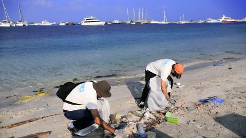 Gruppe reinigt Strand von Plastik.