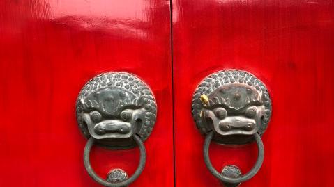 red door with chinese dragon looking door handles