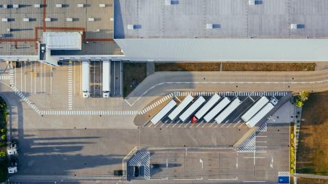 Luftaufnahme von geparkten Lastkraftfahrzeugen und einer Fabrik