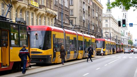 Gelbe Straßenbahn hält an einer Station in der Warschauer Innenstadt