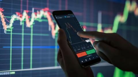 Person tippt auf Smartphone mit Grafik im Hintergrund