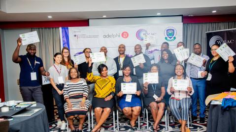 Teilnehmende der Green Finance Academy Workshops in Sambia halten ihr Zertifikat hoch, das sie nach der Teilnahme erhalten haben
