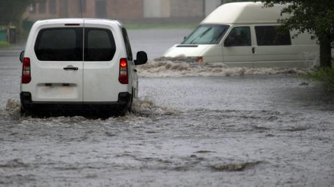 car rides in heavy rain on a flooded road