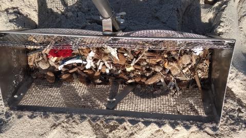 Trash collected in a tool to comb the beach
