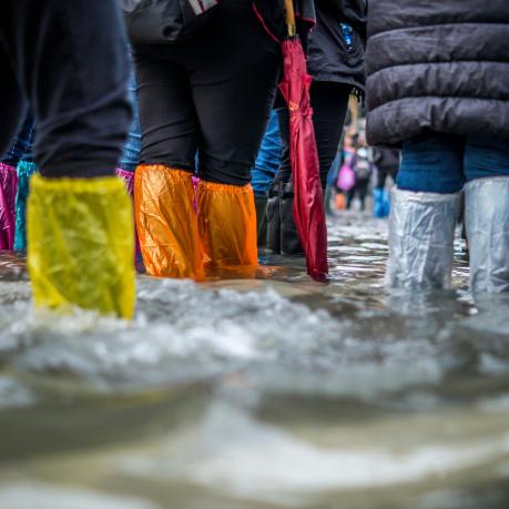 Flood on the streets, people wearing plastic bags on their shoes to walk through the water