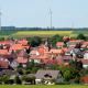 Deutsches Dorf mit Windkraftanlagen im Hintergrund