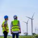 two engineers inspecting wind turbines on a field