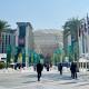 Man sieht den Eingang der COP28 in Dubai, mehrere Menschen befinden sich auf dem Weg zum Eingan
