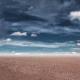 Gray clouds hang over barren desert. 