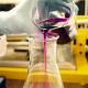 Eine Hand gießt eine lila Chemikalie in ein Reagenzglas. 