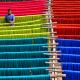 Ein Arbeiter kontrolliert farbige aufgehängte Textilfasern in Indien